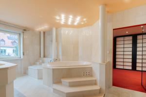 a white bathroom with a tub and a sink at Sonnendurchflutetes 215qm Loft für 6 Personen in Nürnberg +7 photos