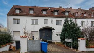 a large white house with a blue door at Sonnendurchflutetes 215qm Loft für 6 Personen in Nürnberg