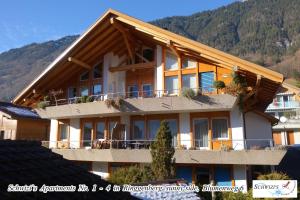 a large building with a mountain in the background at Schwizi's Apartments in Ringgenberg