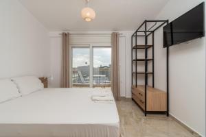 ニキティにあるOASIS luxury apartments and rooms nikitiの白いベッドと大きな窓のある寝室