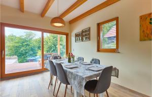 una sala da pranzo con tavolo e sedie e una grande finestra di Nice Home In Rakov Potok With Wifi a Rakov Potok