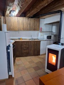 a kitchen with a stove with a fire in it at Apartamento Valdelinares,Casa la roca in Valdelinares