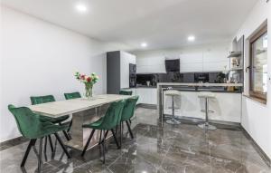 a kitchen with a dining table and green chairs at Awesome Home In Koritna With Sauna in Koritna