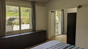 une chambre avec un lit et deux grandes fenêtres dans l'établissement Oxyzenvilla 34800 Lacoste, à Lacoste 21 autres photos