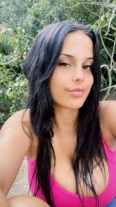 a young woman in a pink dress sitting at Casa de aluguel da vitoria in Ubatuba