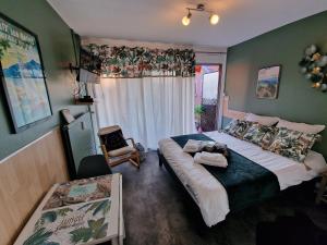 Un dormitorio con una cama y una silla y una ventana. en L'Aixotique, en Aix-les-Bains 44 fotos más