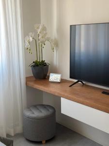 a television sitting on a wooden shelf with a stool at B&B Prestige Apartment - Metropolitana MM1 - Duomo San Babila Milano centro - Castello Sforzesco - Stadio San Siro - Forum Assago - Fiera Milano in Corsico
