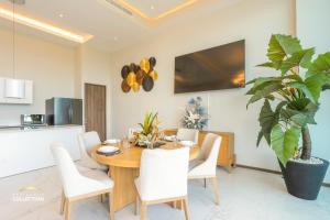 a dining room with a wooden table and white chairs at Maritima Playa Luxury Condo 6O in Bucerías