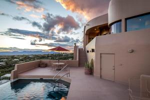 une maison avec une piscine au coucher du soleil dans l'établissement The Schloss 5Bd Hilltop Estate, à Tucson