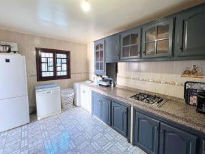 a kitchen with blue cabinets and a white refrigerator at Maison de Vacances Idéale à 10 min de l'Aéroport in Marrakech