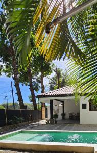 a house with a swimming pool and a palm tree at Zoa Villas - Santa Teresa - 2 min walk to beach in Santa Teresa Beach