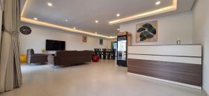 Una sala de estar con un sofá y un televisor en una habitación. en les Résidences Lorenzini, en Yamoussoukro