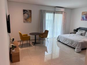 Un dormitorio con una cama y una mesa y sillas. en les Résidences Lorenzini, en Yamoussoukro