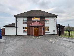 a building with a sign on it in a parking lot at The Bell and Bottle in Hedgerley