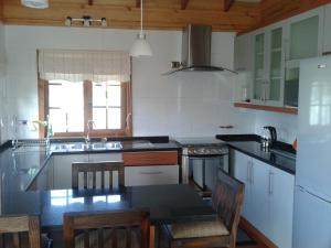 Cabañas Los Tilos Pucón في بوكون: مطبخ مع طاولة وكراسي في مطبخ