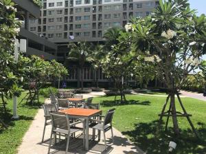 a table and chairs in a park with a building at LPN Premium Apartment Pattaya in Pattaya North