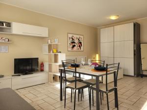 ein Wohnzimmer mit Tisch und Stühlen und einem Fernseher in der Unterkunft Belgioioso Apartments - Monolocale in Belgioioso