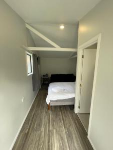 an empty room with a bed and an open door at 2 Double Beds including 1 Sofa Bed Garden Charlet unit C, 9 Steles Lane, Rotorua in Rotorua