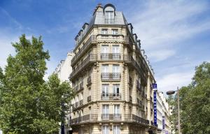 ein hohes Gebäude mit Balkon an der Seite in der Unterkunft Timhotel Paris Gare Montparnasse in Paris