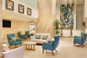 a waiting room with chairs and a couch and a table at Ramada by Wyndham Downtown Dubai in Dubai