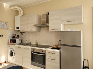 eine Küche mit Kühlschrank und Mikrowelle in der Unterkunft Belgioioso Apartments - Monolocale in Belgioioso