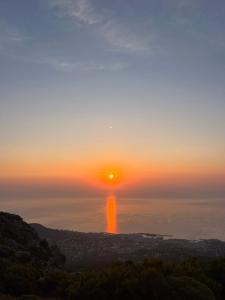a sunset over the ocean with the sun in the sky at Location Patrimonio in Patrimonio