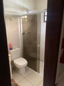 un bagno con wc e doccia in vetro di Casa família com piscina a Garopaba Altre 8 foto