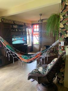 un'amaca in un soggiorno con TV di Casa família com piscina a Garopaba
