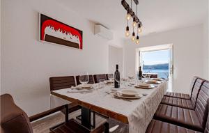 una sala da pranzo con un lungo tavolo e bicchieri da vino di Awesome Home In Kuciste With Wifi a Kučište