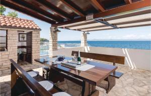 eine Terrasse mit Tisch und Stühlen und dem Meer in der Unterkunft Gorgeous Home In Prigradica With Wifi in Prigradica