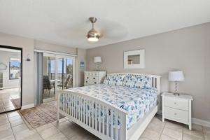 Un dormitorio con una cama y un balcón. en Relax & Chill Beachside-Heated Pool, en Daytona Beach Shores