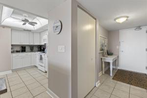 Una cocina con gabinetes blancos y un reloj en la pared. en Relax & Chill Beachside-Heated Pool, en Daytona Beach Shores