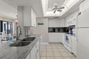 Una cocina blanca con fregadero y refrigerador. en Relax & Chill Beachside-Heated Pool, en Daytona Beach Shores 37 fotos más