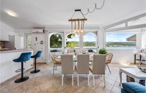 a kitchen and dining room with a table and chairs at Stunning Home In Rogoznica in Rogoznica