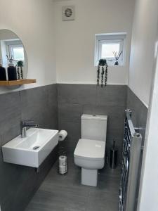 a bathroom with a white toilet and a sink at Spacious 6-Bed Home With 4 Parking Spaces in Oxford +8 photos
