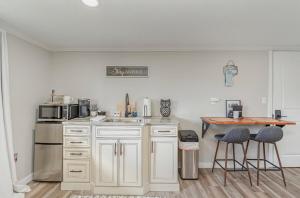 a kitchen with white cabinets and a table with stools at Adorable Clare Guest Suite! in Clare