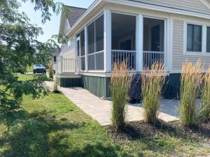 a house with a screened porch with tall grass at The Phoebe - 65 Butternut in Cherry Valley +81 photos