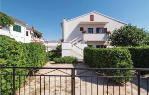 a white building with a fence in front of it at 2 Bedroom Awesome Apartment In Pag in Pag
