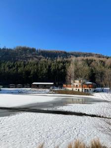 a snow covered field with a building in the background at Apartmány Kašper in Levoča