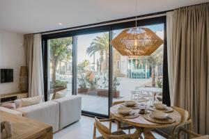 a living room with a table and a large window at MiFlow Hotel Villas & Suites in Miami Platja