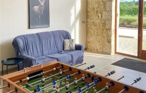 a living room with a blue couch and a table with toy figures at Awesome Home In Lussas Et Nontronneau in Lussas-et-Nontronneau +25 photos