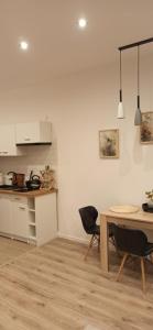 a kitchen and dining room with a table and chairs at Studio Żdanowska Zamość in Zamość