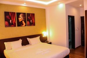 a hotel room with a bed with a white bedspread at HOTEL COLONIA in Dakar