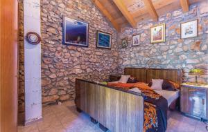 a bedroom with a bed and a stone wall at 5 Bedroom Awesome Home In Ledenice in Ledenice