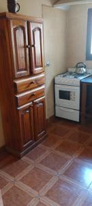 a kitchen with a stove and a wooden cabinet at Usina Elias in Tilcara +10 photos