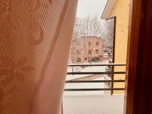 a window with a view of a balcony with snow at Romeo House in Campo di Giove