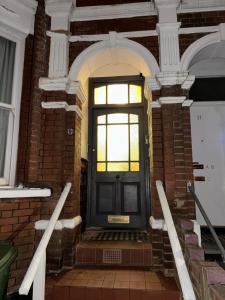 a brick building with a black door and a window at Central London Private Bedrooms in Finsbury Park Station in London