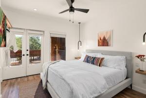 Un dormitorio blanco con una cama y un ventilador de techo. en Pric kly Pear Villa, en Sedona