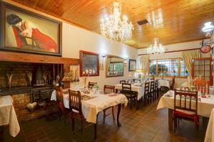 a restaurant with tables and chairs and a painting on the wall at Thylitshia Villa Country Guest House in Oudtshoorn