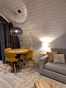 a dining room with a table and chairs and a couch at The Ness, Lodge with Hot Tub in Crieff